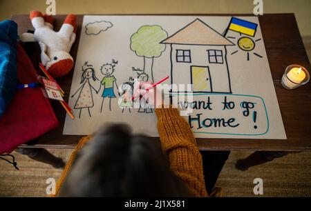 Vue de dessus de la jeune fille ukrainienne réfugiée qui manque à la maison et qui attire sa famille. Concept de guerre d'Ukraine. Banque D'Images