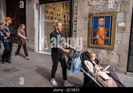 Barcelone, Espagne. 28th mars 2022. Les gens marchent derrière les barreaux devant un portrait de Vladimir Poutine. Vladimir Poutine derrière les barreaux est représenté dans le nouveau collage graphique public de la Plaza de Sant Jaume par l'artiste italien TvBoy basé à Barcelone. Crédit : SOPA Images Limited/Alamy Live News Banque D'Images