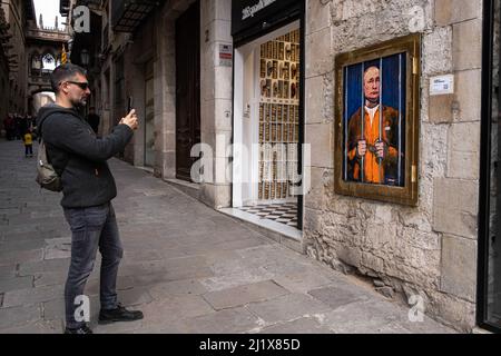 Barcelone, Espagne. 28th mars 2022. Un homme prend une photo du portrait de Vladimir Poutine derrière les barreaux. Vladimir Poutine derrière les barreaux est représenté dans le nouveau collage graphique public de la Plaza de Sant Jaume par l'artiste italien TvBoy basé à Barcelone. Crédit : SOPA Images Limited/Alamy Live News Banque D'Images