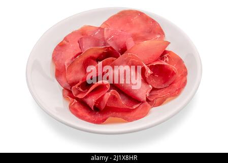 Bresaola Della Valtellina - tranches de bœuf séchées à l'air italien dans une assiette blanche isolée sur blanc avec un chemin de coupure Banque D'Images