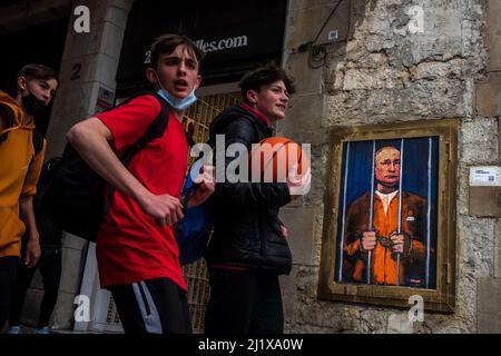 Barcelone, Espagne. 28th mars 2022. Les voyageurs se promeuvent devant un graffiti de l'artiste urbain italien 'TVBoy', Salvatore Benintende, intitulé 'le rêve' représentant le président russe Vladimir Poutine emprisonné et derrière les barreaux pour protester contre les attaques russes en cours Credit: Matthias Oesterle/Alamy Live News Banque D'Images