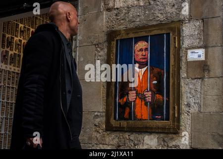 Barcelone, Espagne. 28th mars 2022. Un groupe de banlieue passe devant un graffiti de l'artiste urbain italien 'TVBoy', Salvatore Benintende, intitulé 'le rêve' représentant le président russe Vladimir Poutine emprisonné et derrière les barreaux pour protester contre les attaques russes en cours Credit: Matthias Oesterle/Alamy Live News Banque D'Images