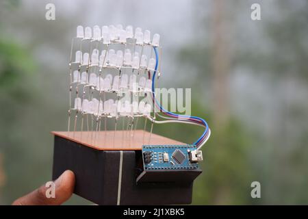Cube lumière LED qui est un projet électronique impressionnant tenu à la main. Projet de microcontrôleur contrôlant plusieurs diodes électroluminescentes Banque D'Images