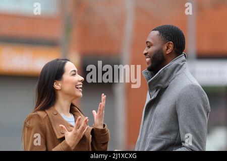 Vue latérale portrait d'une relation interraciale heureuse avec la femme et l'homme parlant dans la rue Banque D'Images