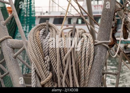 Plusieurs cordes nautiques prêtes à être utilisées sur le pont d'un bateau de pêche commercial à amarina à Rockport, Texas, en gros plan avec une concentration limitée et de faible profondeur Banque D'Images