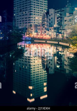 Prise de vue de la rivière Ooka (大岡川) qui serpente le long de la rue Hinode Sakura Michi (日の出さくら道), près de la station Hinodecho, avec des reflets d'un ap en hauteur Banque D'Images