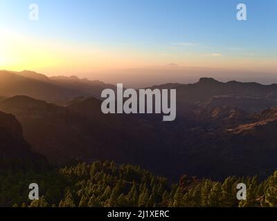 Coucher de soleil époustouflant au-dessus des montagnes rugueuses de l'île de Gran Canaria, des îles Canaries, de l'Espagne avec un ciel spectaculaire coloré, des rayons de soleil visibles et de Ténérife. Banque D'Images