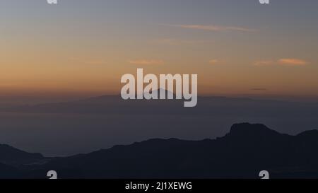 Vue panoramique sur l'île de Ténérife avec le Mont Teide après le coucher du soleil et le ciel coloré de Roque Nublo, Gran Canaria, îles Canaries, Espagne. Banque D'Images