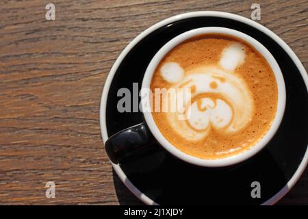 Latte art, dessin du visage de l'ours, café art réalisé par le barista sur une table en bois, vue du dessus ou du dessus. Copier l'espace pour le texte sur la gauche Banque D'Images