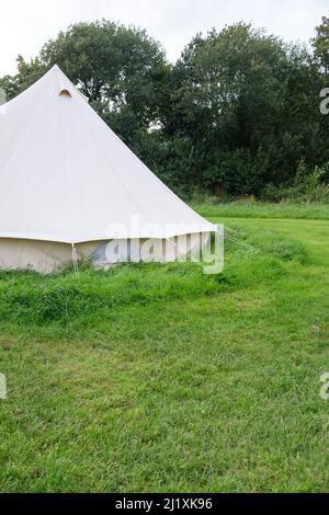 Une tente cloche en toile de style ancien à un emplacement de camp dans un terrain vert luxuriant mis en place pour le camping chic également connu sous le nom de glamping. Banque D'Images