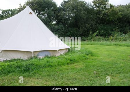 Une tente cloche en toile de style ancien à un emplacement de camp dans un terrain vert luxuriant mis en place pour le camping chic également connu sous le nom de glamping. Banque D'Images