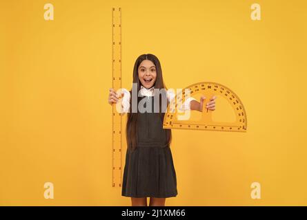 bonne adolescente tient la règle de protracteur. retour à l'école. algèbre et géométrie. enfant étude mathématique. Banque D'Images