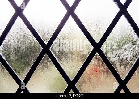 Une vieille fenêtre au plomb avec condensation sur la vitre. Banque D'Images