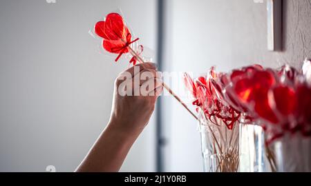 Des sucettes rouges en forme de cœur sur le comptoir d'un magasin de bonbons. Banque D'Images