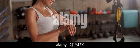 Une jolie femme se tient dans la salle de gym près de la bande d'étirement Banque D'Images