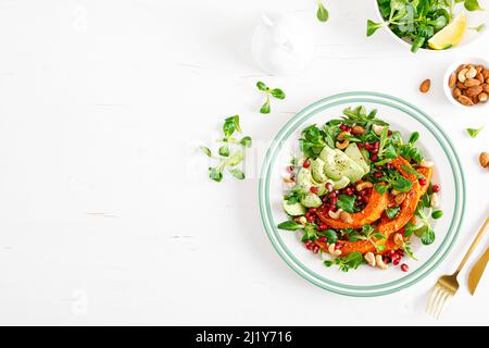 Salade de légumes frais avec laitue agneaux, courge de noyer cendré cuit au four ou citrouille, avocat, grenade, noix de cajou et d'amande. Nourriture végétarienne saine con Banque D'Images