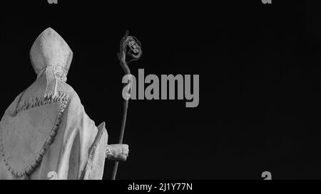 Église catholique. Évêque à onglet et crosier, une ancienne statue en marbre blanc sur les vieux murs de Lucques, érigée au 17th siècle (noir et blanc avec copie Banque D'Images