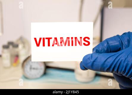Médecin tenant des vitamines de mot sur le carton, concept médical. Banque D'Images