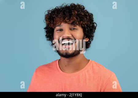 Portrait de jeune Indien charmant et joyeux sur le bleu Banque D'Images