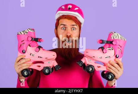 Surpris homme barbu dans un casque de sport avec patins à roulettes. Un mode de vie sain. Balade à roulettes. Banque D'Images