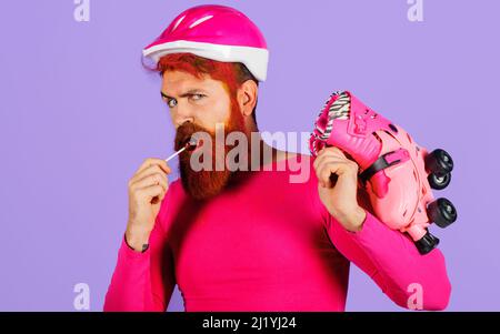 Homme dans un casque avec patins à roulettes et sucettes. Équipements sportifs. Style de vie sportif actif. Vacances. Banque D'Images