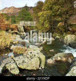 Passerelle en bois Pont au-dessus d'un rocher parsemé de Langstrath Beck dans le parc national du district de Autumn Lake Cumbria Royaume-Uni Banque D'Images