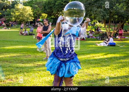 Goias, Brésil – 01 mars 2022 : une fille soufflant de bulles de savon géantes. Photo prise pendant le Carnaval de rue dans un parc public de la ville. Banque D'Images