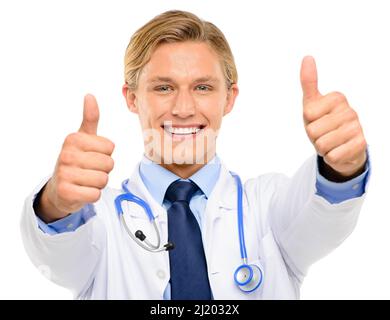 Vous êtes sur la voie de la récupération. Prise de vue d'un beau jeune médecin debout seul dans le studio et montrant un pouce vers le haut. Banque D'Images