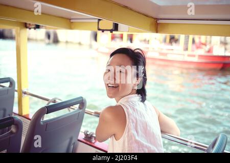C'est le jour idéal pour une promenade en bateau. Portrait court d'une jeune femme attrayante explorant la ville seule sur un ferry pendant la journée. Banque D'Images