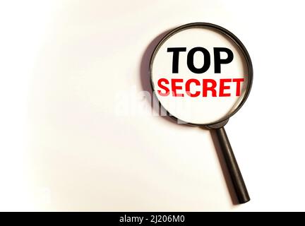 Loupe avec texte Top Secret sur table en bois Banque D'Images