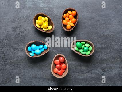 Demi-œufs de Pâques avec différentes friandises sur fond sombre Banque D'Images