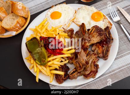 Repas combiné de churrasco avec des frites, des œufs frits et des poivrons Banque D'Images