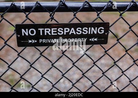 Barrière noire à maillons de chaîne sans panneau d'intrusion, menant à un avis de propriété privée. Banque D'Images