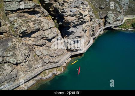 Kayakistes par pont en porte-à-faux sur la piste cyclable du lac Dunstan, lac Dunstan, près de Cromwell, Central Otago, South Island, Nouvelle-Zélande - drone aérien Banque D'Images