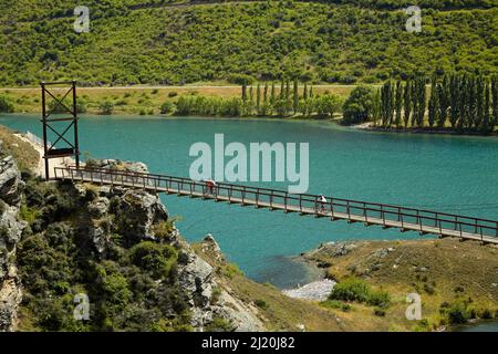 Pont suspendu Hugo sur le sentier du cycle du lac Dunstan et le lac Dunstan, près de Cromwell, Central Otago, South Island, Nouvelle-Zélande Banque D'Images