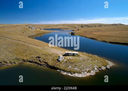 Vieux bus Dunedin par Logan Burn Reservoir (alias Great Moss Swamp), près de Old Dunstan Trail, Central Otago, South Island, Nouvelle-Zélande - drone aérien Banque D'Images