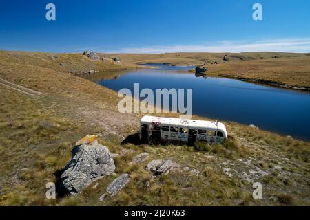 Vieux bus Dunedin par Logan Burn Reservoir (alias Great Moss Swamp), près de Old Dunstan Trail, Central Otago, South Island, Nouvelle-Zélande - drone aérien Banque D'Images