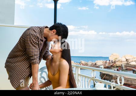 Amoureux qui sont tombés amoureux sur le balcon d'un hôtel de bord de mer - photo de stock Banque D'Images