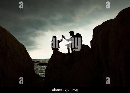 Les amoureux de alpiniste célèbrent, silhoueté - photo de stock Banque D'Images