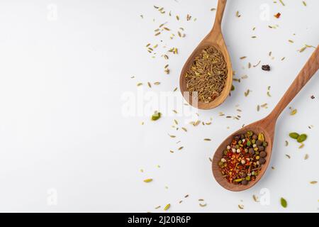Épices colorées dans les cuillères en bois sur fond blanc. Banque D'Images