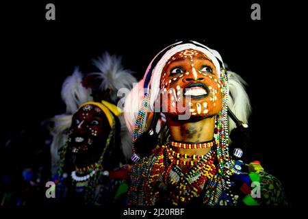 Deux hommes du groupe ethnique Wodaabe dansant et chantant avec des visages peints lors de la fête de Gerepol, un rassemblement de clans différents dans lesquels les femmes cho Banque D'Images