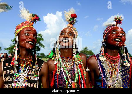 Trois hommes de la tribu nomade Wodaabe célébrant Gerepol, un rassemblement de clans différents dans lequel les femmes choisissent un mari. Les hommes s'habillent dans les meilleurs vêtements et Banque D'Images