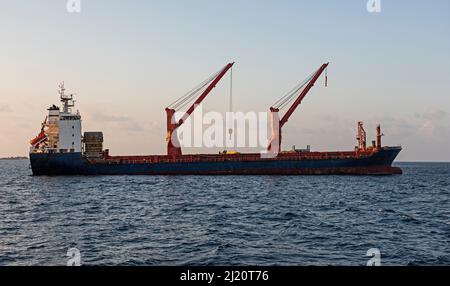 Gros navire de soute à l'ancre sur la mer avec grues à flèche et superstructure Banque D'Images