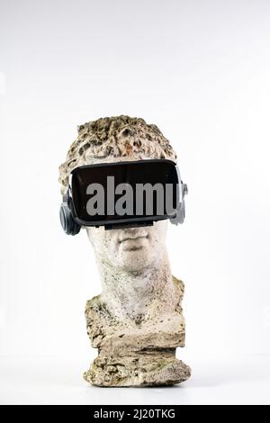 Statue ancienne avec lunettes VR sur fond blanc. Concept d'art et réalité virtuelle. Banque D'Images