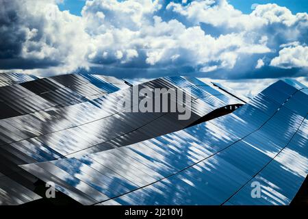 Panneaux de silicone de batteries solaires contre le ciel nuageux au milieu de la journée. Banque D'Images