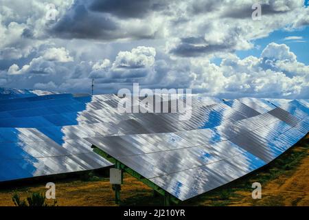 Panneaux de silicone de batteries solaires contre le ciel nuageux au milieu de la journée. Banque D'Images