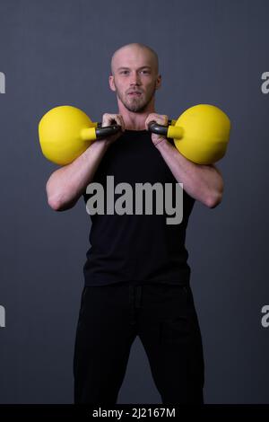 Guy avec un jaune kettlebell Gym anonyme jeune homme, dans l'après-midi FIT adolescent pour peint de la resitance haltérophilie, asiatique philippin. Vie Banque D'Images