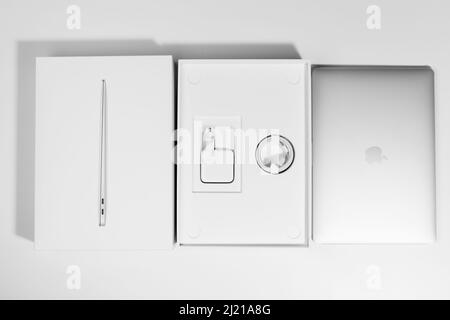 Saratov, Russie - 26 février 2022 : disposition séquentielle du processeur MacBook Air 13 pouces M1 et emballage avec accessoires, fond blanc Banque D'Images