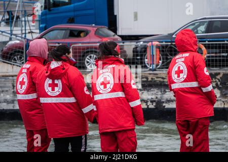 Les volontaires de la Croix-Rouge attendent le ferry entrant pour amarrer et accueillir les personnes déplacées qui ont besoin d'aide, à Isaccea, Roumanie, le vendredi 25 mars, 2022. Photo par Anca Gheonea/ABACAPRESS.COM Banque D'Images