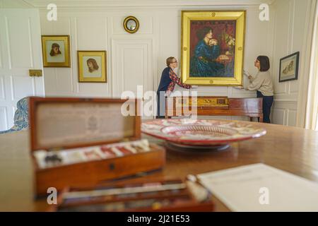 Le personnel ajuste le tableau 'Mrs William Morris portant la robe de soie bleue' par Dante Gabriel Rossetti, 1868 ans, au Kelmscott Manor à Oxfordshire, la maison de campagne de William Morris, avant sa réouverture au public le 1 avril. La maison a bénéficié d'une conservation et d'une rénovation financées par la Loterie du patrimoine de £6 millions. Date de la photo: Mardi 29 mars 2022. Banque D'Images